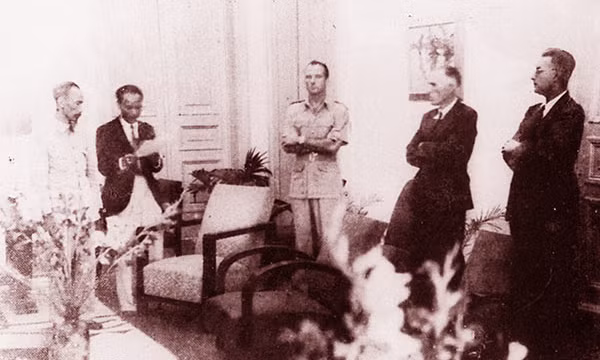 Chủ tịch Hồ Chí Minh và Sainteny (đứng giữa) đại diện Chính phủ Pháp cùng đại diện các nước Đồng minh nghe đọc văn bản Hiệp định Sơ bộ ngày 6/3/1946 trước khi ký kết. Ảnh: Nguyễn Bá Khoản.