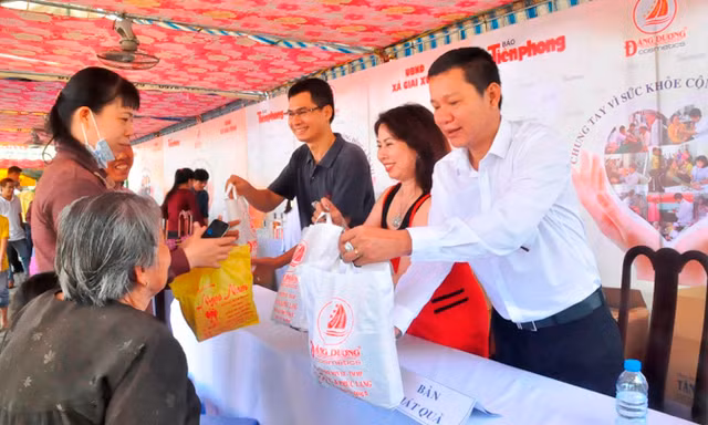 Đại diện báo Tiền Phong tại TPHCM – Nhà báo Lý Thành Tâm cùng vợ chồng ông Nguyễn Ngọc Lang, Tổng giám đốc Cty Mỹ Phẩm Đăng Dương trao quà cho bà con. Ảnh Việt Văn.