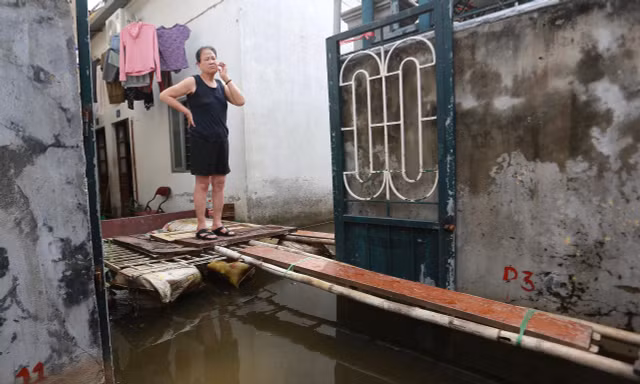 Một tuần sau mưa, người Hà Nội vẫn phải bắc 'cầu khỉ' vượt nước ngập