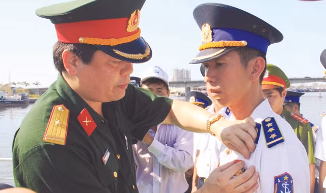 Thiếu tá Thái Đức Hạnh trao Huy hiệu “Tuổi trẻ dũng cảm” cho thuyền trưởng Thượng úy Lê Trung Thành. Ảnh: Nguyễn Huy.