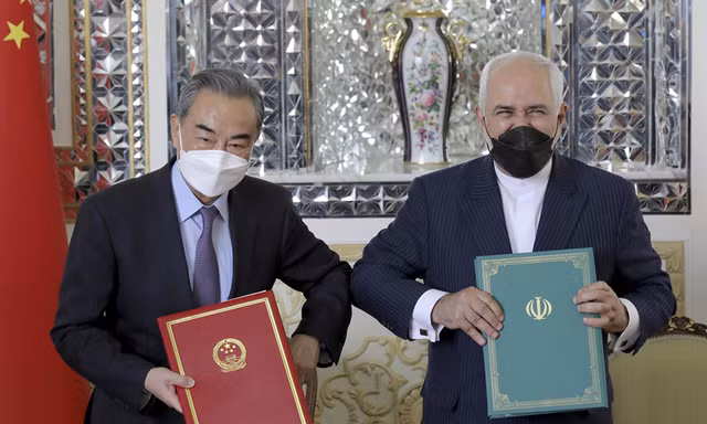 Bộ trưởng Ngoại giao Iran Mohammad Javad Zarif, bên phải, và người đồng cấp Trung Quốc Vương Nghị, chụp ảnh sau buổi lễ ký kết các văn kiện, tại Tehran, Iran, hôm 27/3. | Ebrahim Noroozi / AP