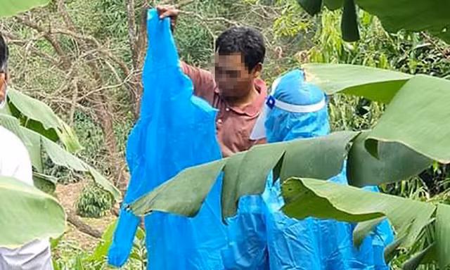 Ông P.T mặc quần áo bảo hộ để quay lại khu cách ly. Ảnh: CTV
