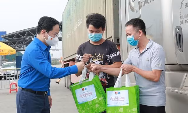 Anh Nguyễn Anh Tuấn, Ủy viên T.Ư Đảng, Bí thư thứ nhất T.Ư Đoàn, Chủ tịch T.Ư Hội LHTN Việt Nam trao quà, động viên tinh thần cho lái xe đường dài khi tại Trạm thu phí cao tốc Pháp Vân - Cầu Giẽ, huyện Tranh Trì. Ảnh: Bảo Anh