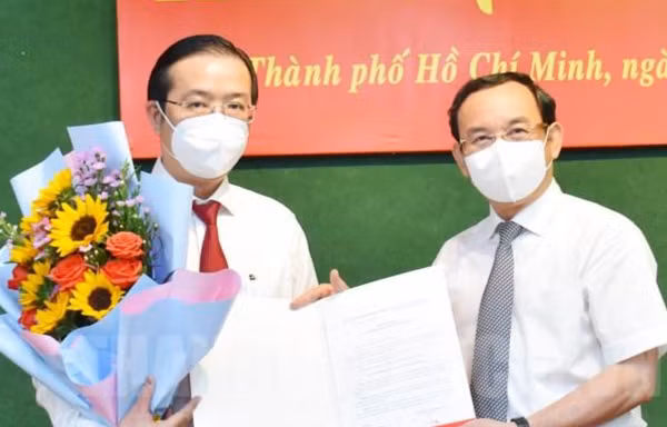 Bí thư Thành uỷ TPHCM Nguyễn Văn Nên trao quyết định điều động cho ông Nguyễn Văn Minh (trái). Ảnh: Thành uỷ TPHCM