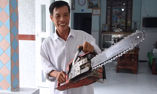 Ông Lê Tấn Thành (Mười Hên) bên chiếc máy cưa đã từng cứu 11 người trong vụ sập nhịp dẫn cầu Cần Thơ (Ảnh Nhật Huy).