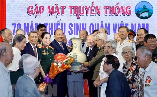 Thủ tướng Nguyễn Xuân Phúc tặng quà lưu niệm cho các cựu học sinh Trường Thiếu sinh quân Việt Nam. (Ảnh: Thống Nhất/TTXVN)