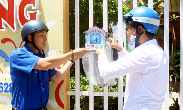 Cứ 2 tuần, anh Phạm Phú Vũ, Bí thư Đoàn phường Phước Ninh (bên trái) đi thu gom pin từ các “Ngôi nhà của pin” Ảnh: Giang Thanh
