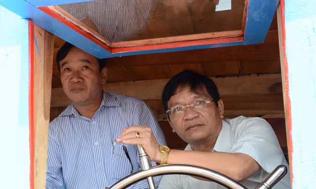Ông Lê Viết Chữ (bên phải) đang cầm lái chiếc tàu Hoàng Sa ảnh: Văn Chương 
