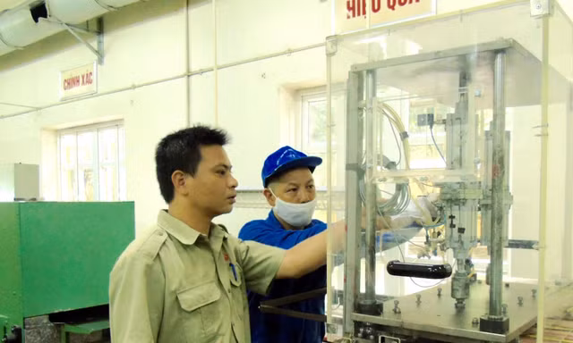 Kỹ sư Nguyễn Tiến Hưng (trái) kiểm tra thiết bị sản xuất sản phẩm quốc phòng tại Nhà máy Z121