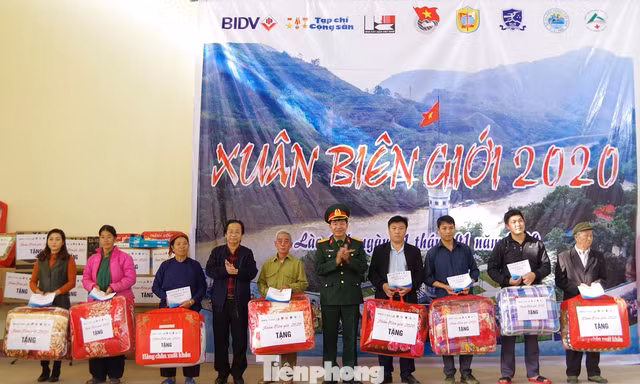 Đại diện Học viện Khoa học Quân sự và Đại học Ngoại ngữ trao tặng quà cho các gia đình ở xã Nậm Chảy