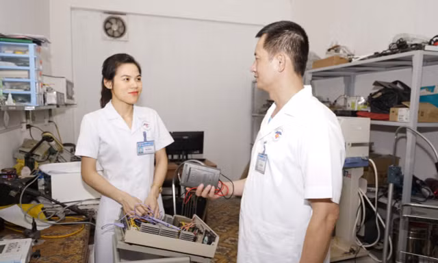 Đại úy Bùi Thị Hoa (bên trái) trao đổi công việc cùng đồng nghiệp 