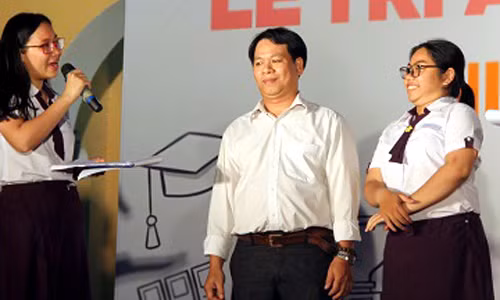 Ông Lê Thanh Bình (giữa) và con gái trên sân khấu lễ trưởng thành. Ảnh: Mi Lăng.