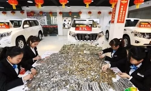 Các nhân viên đại lý ôtô phải đếm đống tiền xu suốt 12 giờ. Ảnh: SCMP.