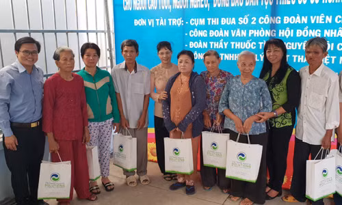 Bà Huỳnh Thị Lan Phương cùng lãnh đạo huyện Bình Chánh trao quà cho bà con