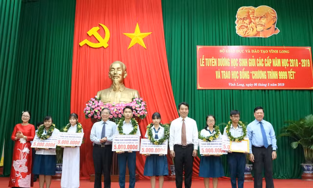 Ông Trần Văn Rón - Bí thư Tỉnh ủy tỉnh Vĩnh Long và ông Lê Vinh - Phó TGĐ AIC Group trao học bổng cho các học sinh .