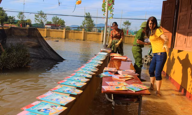 Lũ rút, giáo viên lội nước cao nửa mét vào trường mò tìm sách cho trò