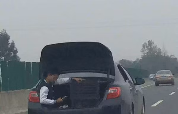 Nam thanh niên vô tư ngồi trong cốp xe khi đi trên cao tốc.