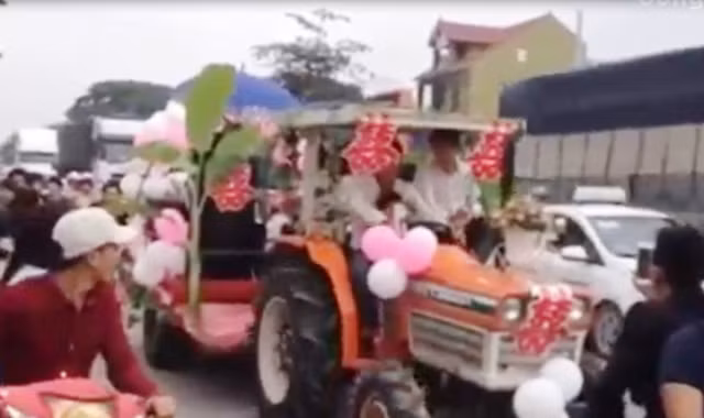Chiếc máy cày được trang trí thành xe hoa “đại náo” quốc lộ 1 A. (Ảnh cắt từ clip).