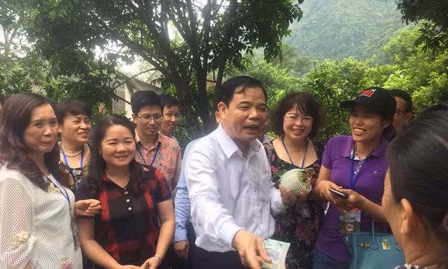 Bộ trưởng Nguyễn Xuân Cường mua na của người dân địa phương. - Ảnh: Hoàng Dự 
