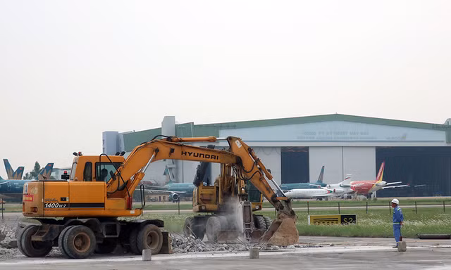Tiến độ thi công sửa chữa, nâng cấp đường băng, đường lăn sân bay Nội Bài đang đáp ứng yêu cầu, nhưng phần thiết kế đèn dẫn đường chậm tiến độ. Ảnh thi công chiều 31/8.