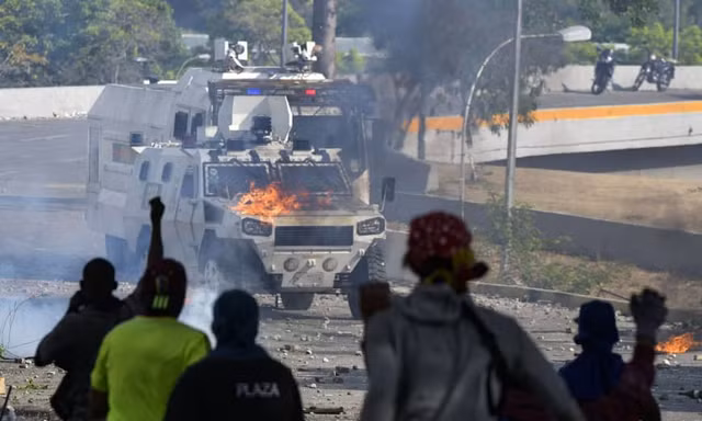 Phe biểu tình phản đối chính phủ đối đầu với lực lượng an ninh Venezuela. (Ảnh: JIJI)