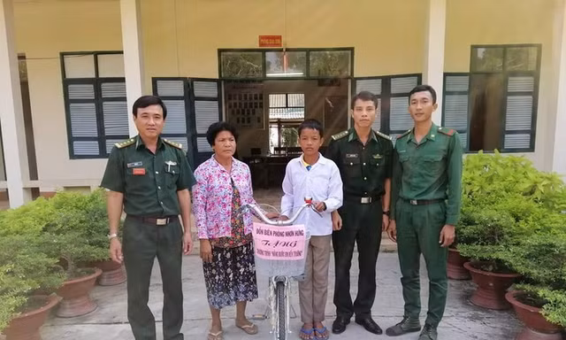 Đại diện Đồn Biên phòng Nhơn Hưng, BĐBP An Giang trao tặng xe đạp cho em Sôn Sun Ly. Ảnh: Chiến Khu