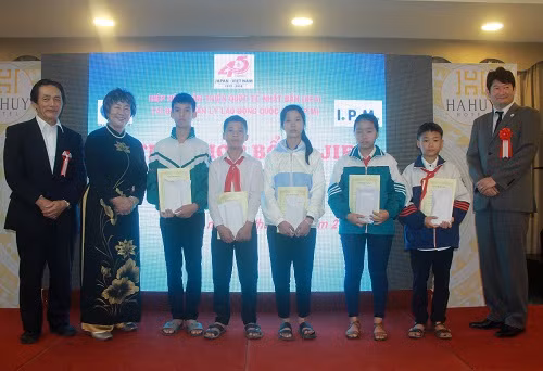 Đại diện JIFA và I.P.M (trái) và đại diện đại sứ quán Nhật Bản tại Việt Nam (phải) chụp ảnh lưu niệm với các em học sinh được trao học bổng 