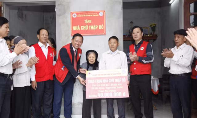 Đại diện lãnh đạo Hội Chữ thập đỏ Thành phố và lãnh đạo huyện Phú Xuyên trao tặng nhà Chữ thập đỏ tới người dân có hoàn cảnh khó khăn