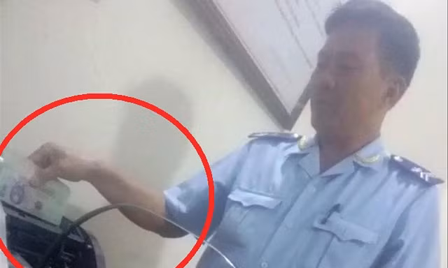 Cảnh cán bộ hải quan cửa khẩu Tây Trang nhận tiền làm luật bằng máy đếm tiền