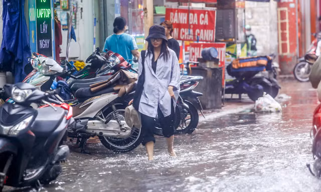 Người dân bì bõm về nhà trên những con phố ngập nước ở Hà Nội 