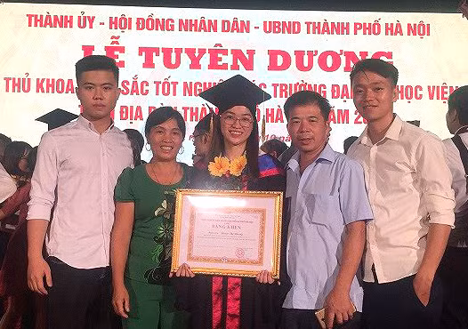 Phạm Thị Nhung bên gia đình tại lễ tuyên dương thủ khoa đầu ra xuất sắc vừa qua.