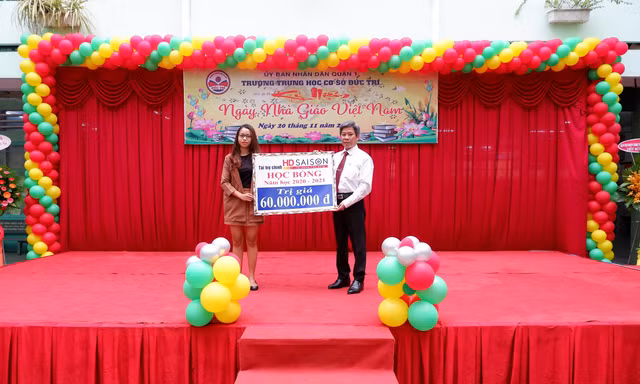 Đại diện HD SAISON trao tặng giá trị học bổng đến Ban giám hiệu nhà trường.