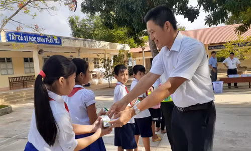 Các thầy cô giáo phát sữa cho các em học sinh nhân ngày đầu tiên bắt đầu uống sữa học đường