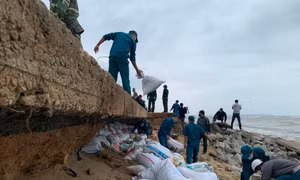 Triều cường xâm lấn, khoét sâu vào lòng đường, uy hiếp hàng chục nhà dân. Ảnh: Nguyễn Ngọc