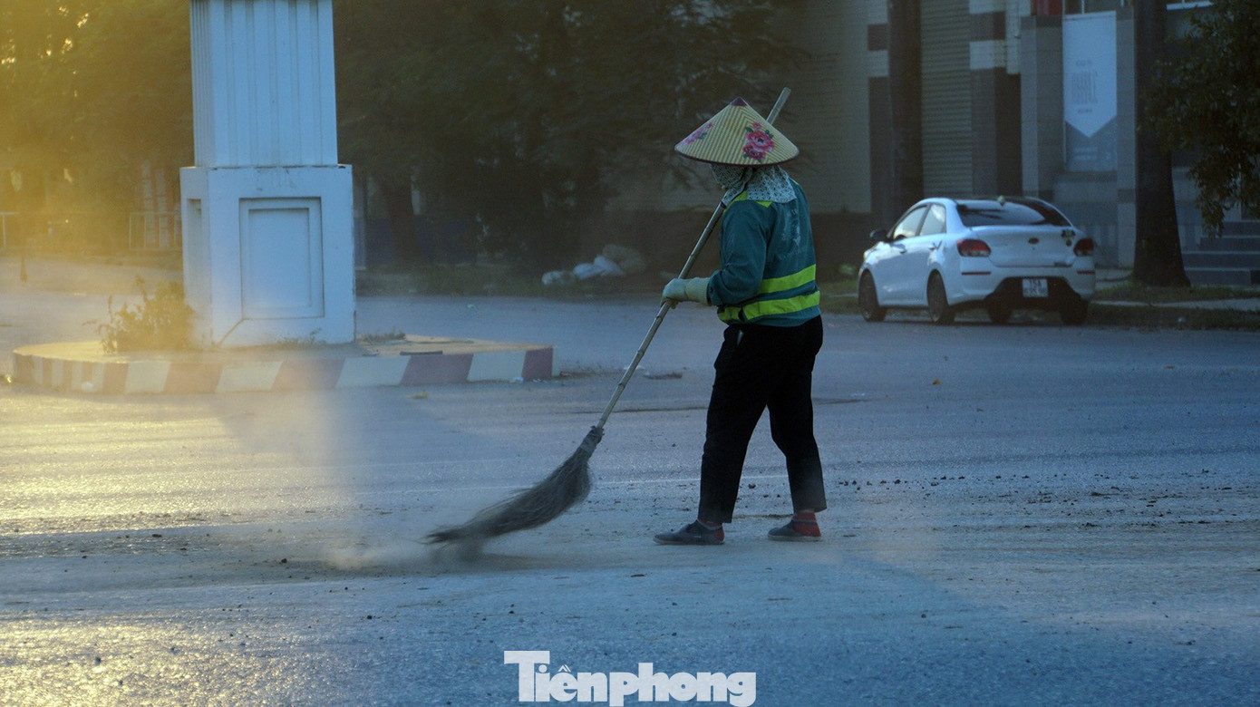 Công nhân vệ sinh môi trường quét đất cát rơi nhưng không xuể do lưu lượng xe tải hoạt động ngày đêm, khối lượng vật liệu rơi vãi rất lớn. tp-bui-18.jpg