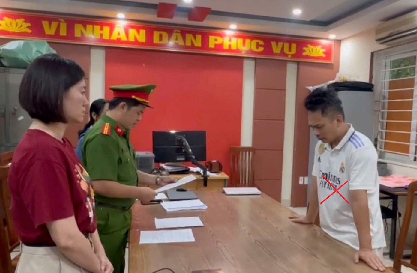 Nguyễn Thành Long (áo trắng) tại cơ quan công an. tien-bip.jpg