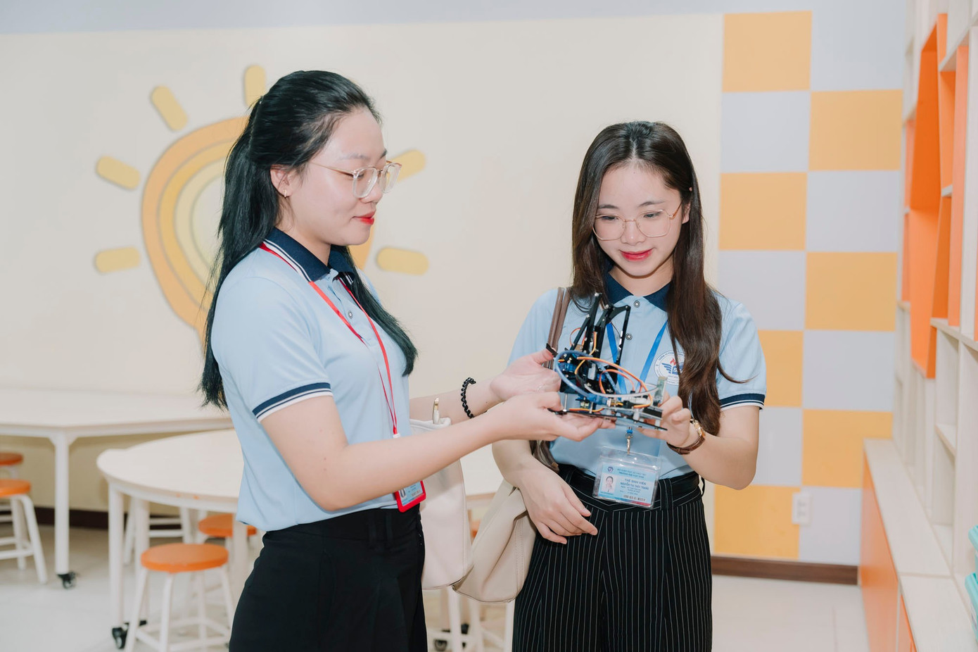 សិស្ស Thanh Tra (ឆ្វេង) ទទួលបានបទពិសោធន៍ពីគំរូមនុស្សយន្តដែលផលិតដោយសិស្សថ្នាក់ទីមួយនៃសាលា FPT Thanh Hoa។ xmn06909.jpg