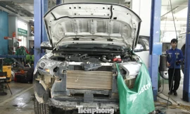 Một xe ô tô trị giá tiền tỷ bị hư hỏng do ngập nước lũ đang sửa chữa tại gara.