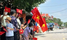 Người dân xã Xuân Cẩm (Bắc Ninh) vẫy cờ xúc động chia tay các chiến sĩ quân đội sau khi hoàn thành nhiệm vụ giúp địa phương chống lũ.