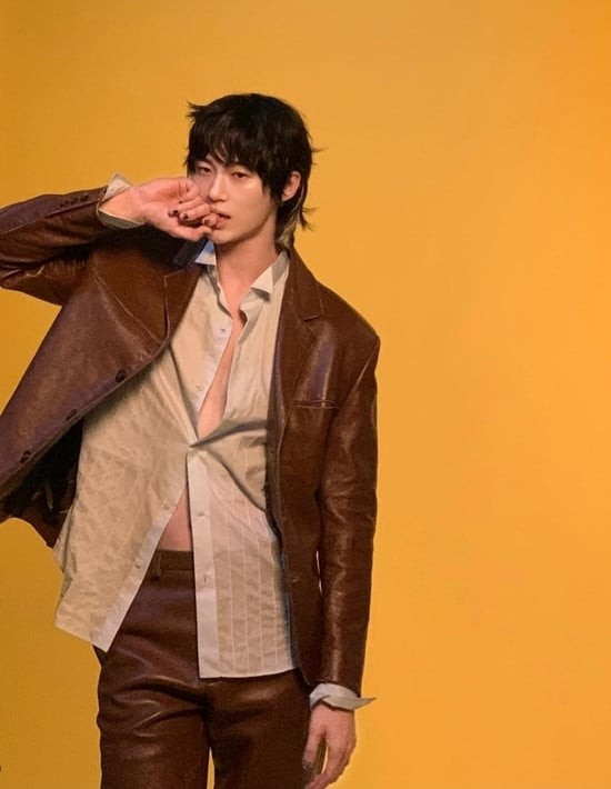 Byeon Woo Seok xuất hiện trong bộ vét da nâu, với chiếc áo sơ mi được xếp lớp bên trong một cách hờ hững, chỉ mở một cúc. Vòng eo trần và cơ bụng lộ ra, kết hợp với vẻ mặt lạnh lùng, tạo nên sự kết hợp hoàn hảo giữa vẻ thanh lịch giản dị và nét gợi cảm kín đáo. 1753266644-news-p.jpg