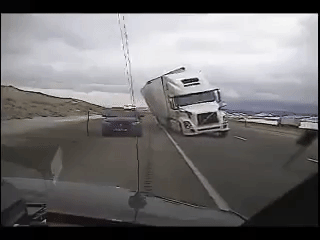 Khoảnh khắc xe container bị gió thổi lật, đè xe cảnh sát bên đường.