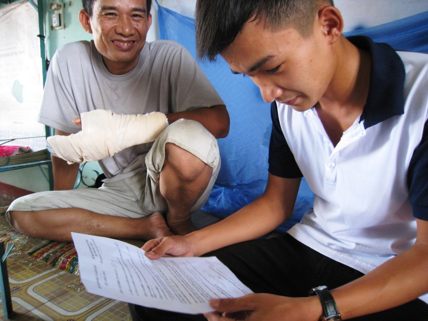 Ông Ơm và con trai xem lại kết quả bài thi môn cuối, trước khi rời Đà Nẵng. Ảnh: Nguyễn Huy