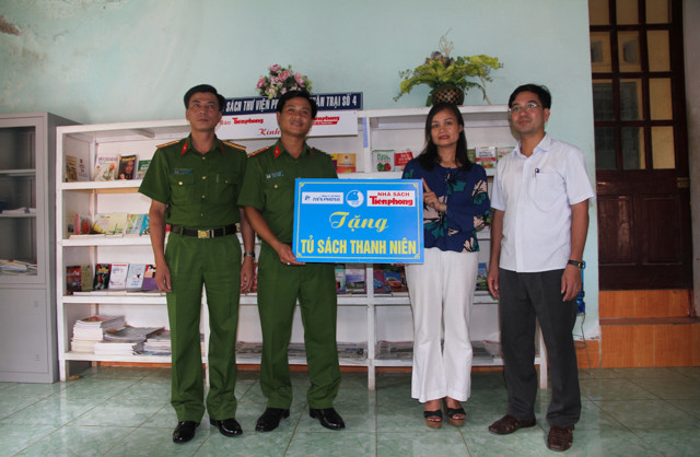 Bà Phạm Ngân Hà – phó tổng giám đốc Công ty cổ phần Tiền Phong, anh Nguyễn Thành Lương, phó bí thư Tỉnh Đoàn Thanh Hóa trao tặng tủ sách cho Trại giam số 5. Ảnh: Hoàng Lam.