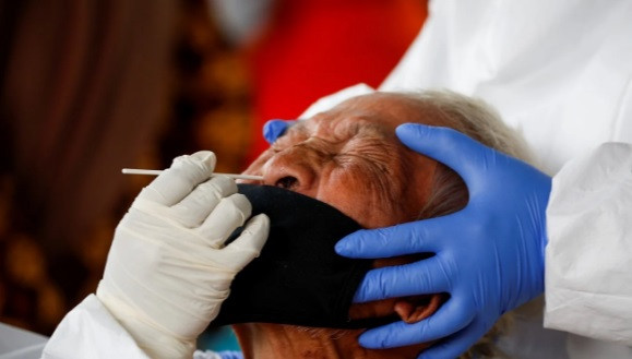 Lấy mẫu xét nghiệm cho tiểu thương tại Tây Java. Ảnh: Reuters