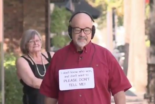 Ông Joe Chandler đeo tai nghe và đeo biển khi ra đường.