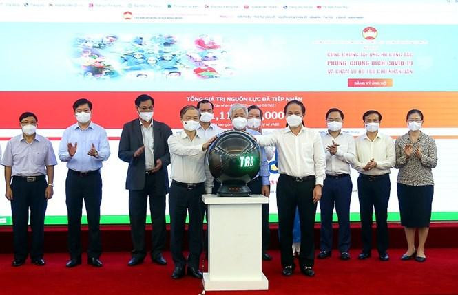 Các đại biểu thực hiện nghi thức bấm nút ra mắt hệ thống đóng góp trực tuyến của Tiểu ban Vận động và Huy động xã hội. Ảnh Kỳ Anh