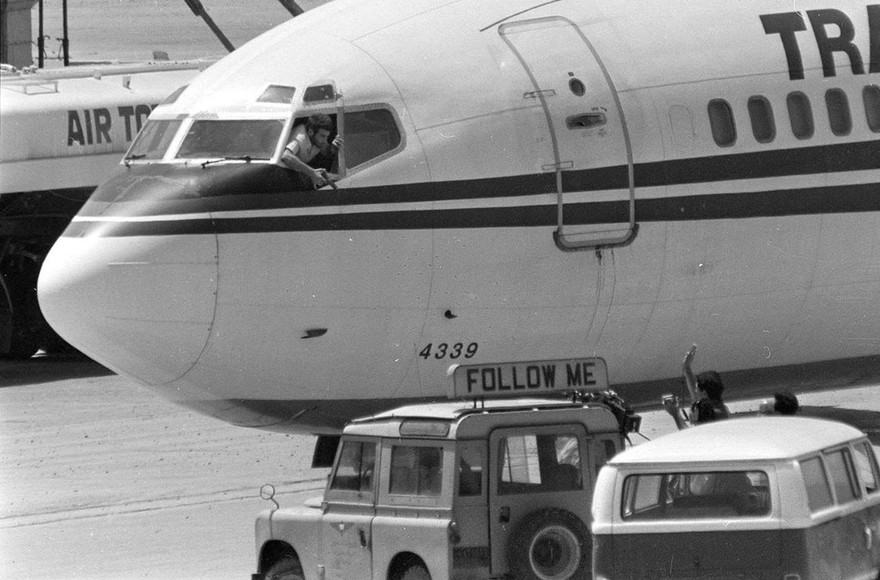 Một tên không tặc cầm súng lục bên cửa sổ máy bay. Ảnh: Getty.