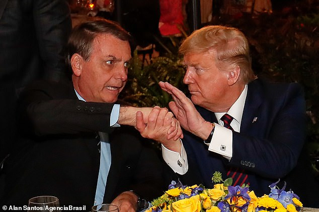 Tổng thống Mỹ Trump bắt tay Tổng thống Brazil Bolsonaro trong cuộc gặp cuối tuần trước. Ảnh: Daily Mail