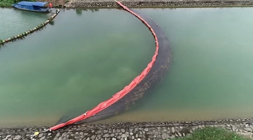 Màng ngăn dầu được lắp xuống kênh nước. Ảnh: G.C