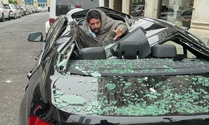 Người đàn ông chưa rõ danh tính rơi trúng chiếc xe BMW. Ảnh: Twitter